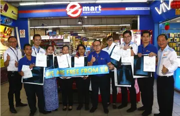  ??  ?? Ngu (right) and Bong (back, second left) join members of Emart Matang management and staff for a photo-call, where they show the results of their TB tests and X-ray scans – confirming that all of them are TB-free. — Photo by Muhamad Rais Sanusi