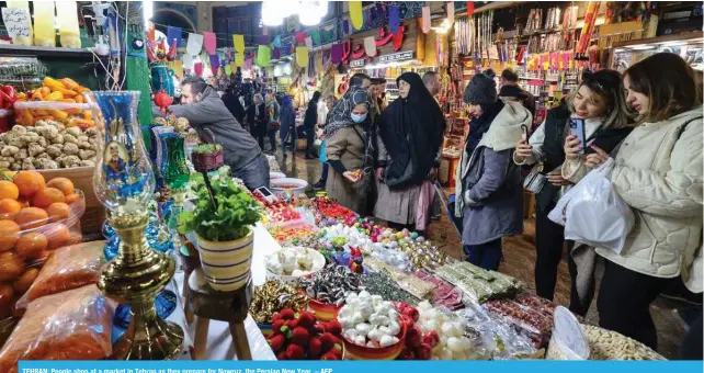  ?? – AFP ?? TEHRAN: People shop at a market in Tehran as they prepare for Nowruz, the Persian New Year.