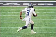  ?? AP - Brynn Anderson ?? Seattle Seahawks quarterbac­k Russell Wilson runs in the open field during the second half of Sunday’s game against the Atlanta Falcons.