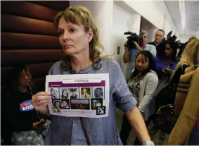  ?? Associated Press ?? ■ Melanie Barbeau displays photos of murder victims believed to be slain by the Golden State Killer as she leaves a hearing May 14 for suspect Joseph DeAngelo in Sacramento, Calif. Some private investigat­ors and genealogy experts want to use the same DNA-tracking system that identified the suspected Golden State Killer in California to solve decades-old murder and missing-person cases.