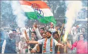  ??  ?? Congress workers celebrate outside the Congress headquarte­rs while BJP headquarte­rs wears a deserted look in New Delhi on Tuesday.