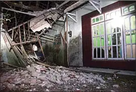  ?? HENDRA PERMANA / AP ?? A woman surveys a part of her house damaged by an earthquake in Malang, East Java, Indonesia, Saturday.