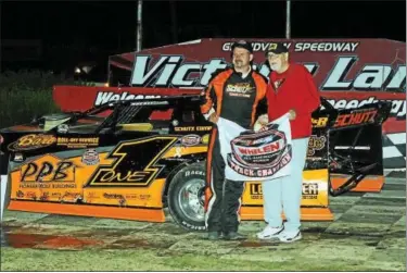  ?? SUBMITTED PHOTO - RICK KEPNER ?? Chuck Schutz, left, holds the track champion banner alongside Grandview Speedway owner Bruce Rogers after capturing the Late Model title on Sept. 3.