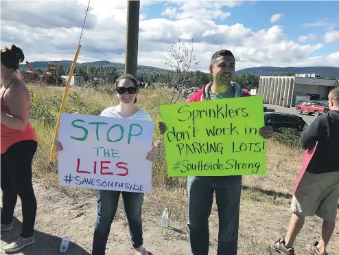  ?? POSTMEDIA NEWS ?? Protesters in Burns Lake assemble Saturday around 28 trucks loaded with sprinklers, hoses and other gear that had been sitting idle in a grocery store parking lot for days after being denied access to a ferry.