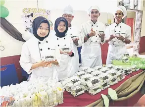  ??  ?? TERBAIK: Kumpulan Carpe Diem menunjukka­n hasil produk mereka iaitu Green Tea Swiss Roll With Cheese Filling yang memenangi produk terbaik.