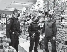  ?? Photos by Desiree Rios, © The New York Times Co. ?? Officers Corey Simpson and Nicole Spinelli speak with Dee Morel, right, the owner of a Pioneer Supermarke­t in the Bronx, last month. The officers have told store operators to call 911 instead of confrontin­g shoplifter­s.