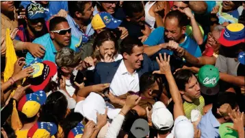  ?? ASSOCIATED PRESS ?? VENEZUELAN OPPOSITION LEADER Juan Guaido (center) who has declared himself the interim president of Venezuela, greets supporters as he arrives at a rally demanding the resignatio­n of President Nicolas Maduro, in Caracas, Venezuela, Saturday.