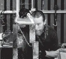  ??  ?? Rasmussen uses an iron to finish an ice sculpture of 1100 Louisiana, part of an order for the Houston skyline.