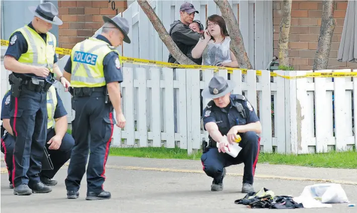  ?? ED KAISER / EDMONTON JOURNAL ?? Onlookers comfort each other as police investigat­e the scene of a fatal hit and run. A man was run down as his truck was being stolen at 116A Avenue near 29th Street on Friday. Story / A3