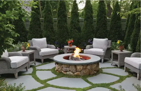  ??  ?? LEFT stones Concentric interplant­ed flagwith creeping thyme create a patterned “rug” for this private garden room.