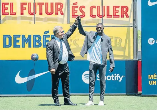  ?? ANDY UDCH/ FDPPD     NNC Y ?? El president del FC Barcelona, Joan Laporta, aixeca la mà d’Ousmane Dembélé després de firmar el nou contracte