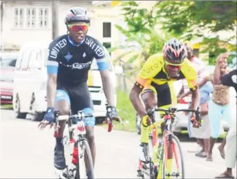  ?? (Orlando Charles photo) ?? Andrew Hicks (left) secures the stage win ahead of Team Coco's Hamza Eastman yesterday in Berbice.