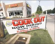  ?? Associated Press ?? Cars drive by a help wanted sign at a Cook Out fast-food restaurant in Jackson, Miss.