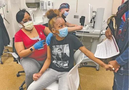  ??  ?? Maliyah Rather, 14, receives her first dose of dose of the Pfizer-BioNTech COVID-19 vaccine at the University of Chicago Medicine on May 13. It was the first day adolescent­s could receive doses of the vaccine.