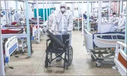  ??  ?? A health worker brings an oxygen cylinder on a wheelchair at the hospital.