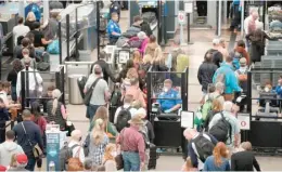  ?? AP ?? Travelers move through security Thursday at Denver Internatio­nal Airport.