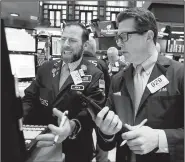  ?? AP/RICHARD DREW ?? Specialist Michael Pistillo (left) and trader James Matthews work on the floor of the New York Stock Exchange on Tuesday.