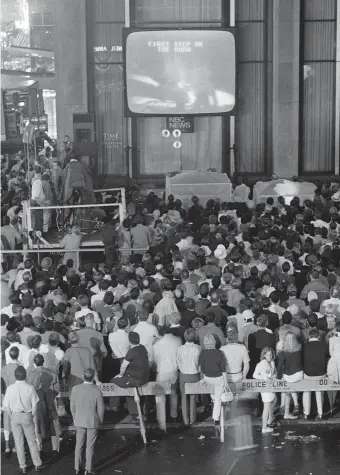  ?? Barton Silverman / New York Times ?? People gather at the Time-Life Building in New York’s Rockefelle­r Center to watch as Neil Armstrong takes his first step on the moon on July 20, 1969.