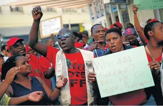  ?? /Reuters/AFP ?? Making a statement: Members of the EFF protest in the streets before President Jacob Zuma’s state of the nation address in Cape Town on Thursday. Left: Zuma takes the national salute.