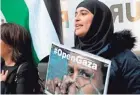  ?? SAMSON/AFP/GETTY IMAGES THOMAS ?? A woman holds a poster during a rally in Paris Tuesday to protest the killing, the day before, of 59 Palestinia­ns in clashes with Israeli forces.