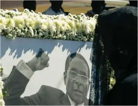  ??  ?? ON THE WAY UP: Mugabe’s portrait [Pic by France 24]