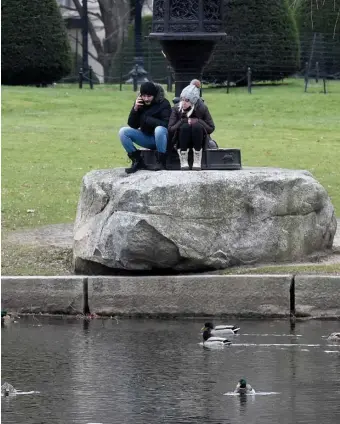  ?? JiM MichauD PhoToS / BoSTon hEraLD ?? FREE ENTERTAINM­ENT: Sofor Mohammed and his girlfriend Yana Berhuk, both of Boston, watch the water fowl enjoying the relatively nice weather prior to the snow and the cold rain to come later on Sunday.