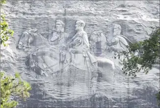  ?? John Bazemore Associated Press ?? A CARVING at Stone Mountain depicts Confederat­e leaders Jefferson Davis, Robert E. Lee and Stonewall Jackson. Some civil rights leaders oppose a plan to build a monument to King nearby.
