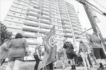  ?? GARY YOKOYAMA THE HAMILTON SPECTATOR ?? Some tenants living at 355 Melvin Ave. listen from their balconies as ACORN marchers inform them of their tenants’ rights during a protest in June.