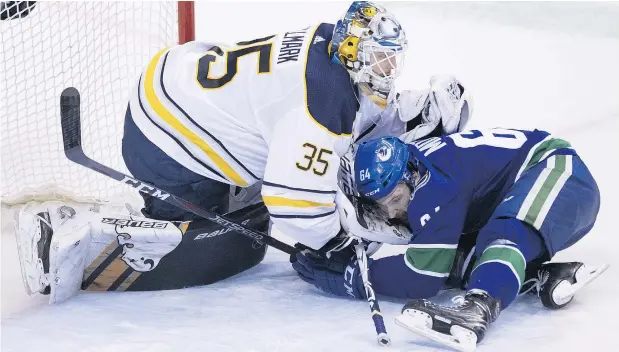  ?? — THE CANADIAN PRESS ?? Canucks centre Tyler Motte slides into Buffalo goalie Linus Ullmark Friday on a night Vancouver seemed determined to attack the front of the net and earn gritty goals. The strategy paid off with a 4-3 victory at Rogers Arena.
