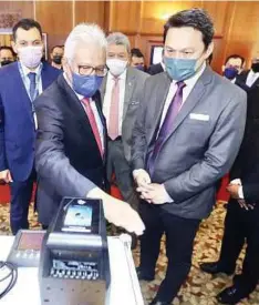  ?? ?? HAMZAH mencuba mesin imbasan tangan tanpa sentuh ketika melawat Pameran Teknologi NIISe, semalam.