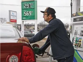  ?? BILL LACKEY / STAFF ?? Ron Fielder fills up his gas tank for $2.97 per gallon Monday at the BP gas station at Home Road and North Limestone Street in Springfiel­d. The national average price of gasoline is about 14 cents away from falling below yearago levels.