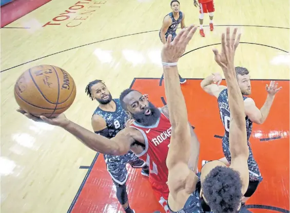  ?? AP ?? Impotentes. Mills, White y Costello no pueden defender el ataque de James Harden al aro en la victoria de Houston frente a San Antonio.