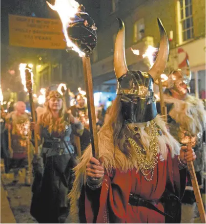  ??  ?? A society parades in Lewes during the yearly bonfire night on November 4.