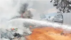  ?? ?? Bomberos lanzan un chorro de agua hacia el cúmulo incendiado.