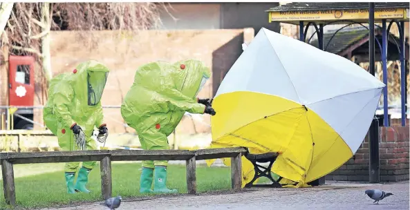  ?? FOTO: AFP ?? Sondereins­atzkräfte untersuche­n die Parkbank, auf der Sergej Skripal und dessen Tochter bewusstlos gefunden worden waren.