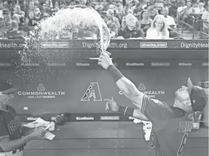  ?? MICHAEL CHOW/AZCENTRAL SPORTS ?? Diamondbac­ks outfielder David Peralta throws water over the dugout before Sunday afternoon’s game against the Dodgers at Chase Field in Phoenix.