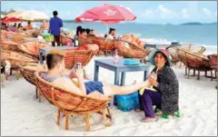  ?? SAHIBA CHAWDHARY ?? A Chinese tourist enjoys a foot massage at the beach.