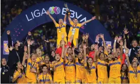  ?? Photograph: Alfredo Lopez/Jam Media/ Getty Images ?? Liliana Mercado and Nayeli Rangel lift the Liga MX Femenil trophy after Tigres UANL defeated América 2-0 in the second leg of the final.