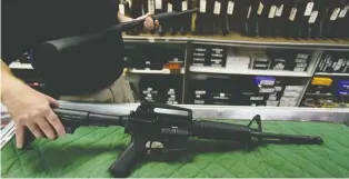  ?? JOSHUA LOTT/GETTY IMAGES ?? A manager at a store and shooting range, who refused to give his name, confirmed sales for the AR-15 were up considerab­ly since MP Tony Clement said in May that Ottawa would institute a ban.