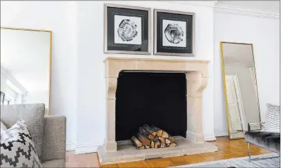  ?? Tribune News Service ?? Affordable floor mirrors help add polish to this living room fireplace.