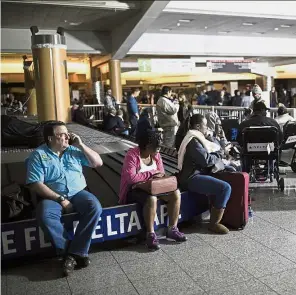  ?? AP ?? In the dark: Passengers waiting after the lights went out at HartfieldJ­ackson Atlanta Internatio­nal Airport. —