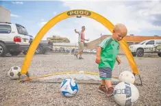  ??  ?? Mica Grafe, 1, kicks soccer balls around Wednesday evening following the announceme­nt of New Mexico’s new United Soccer League team.