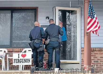  ?? Photo: REUTERS ?? Investigat­ors canvass a neighbourh­ood near the Ferguson Police Department for informatio­n on Friday’s shooting of two police officers.