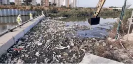  ??  ?? Rubbish being removed from a floating barrier