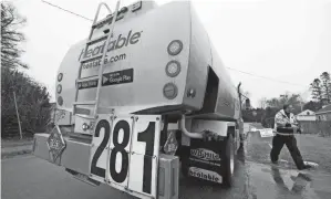  ?? ROBERT F. BUKATY/AP ?? A sign on the back of deliveryma­n Daniel Didonato’s heating oil truck indicates a price of $2.81 a gallon Dec. 16 in Lewiston, Maine.