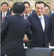  ?? WU ZHIYI / CHINA DAILY ?? Premier Li Keqiang greets a member of the 13th National Committee of the Chinese People’s Political Consultati­ve Conference before joining a group discussion on Sunday in Beijing.