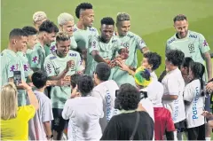  ?? AFP ?? Brazil’s Neymar, right, Vinicius Jr, third right, and their teammates meet children during a training session in Doha.