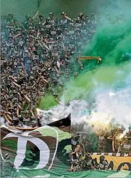  ??  ?? Kriegsmont­ur und Rauchbombe­n: Fans von Dynamo Dresden sorgten vor und während des Gastspiels in Karlsruhe für Aufruhr. Foto: Steffen Kuttner, Imago