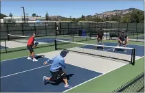  ?? SHERRY LAVARS — MARIN INDEPENDEN­T JOURNAL, FILE ?? From left, George Silvas watches as his doubles partner Misha Posylkin returns a shot to their opponents Russ Wilson and Don Scheppler while playing pickleball on the new courts at Hill Recreation Area in Novato.