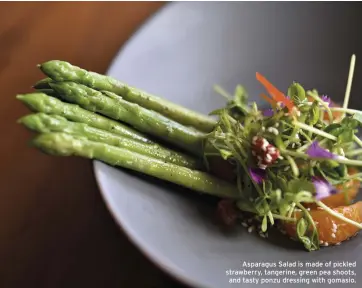  ??  ?? Asparagus Salad is made of pickled strawberry, tangerine, green pea shoots, and tasty ponzu dressing with gomasio.